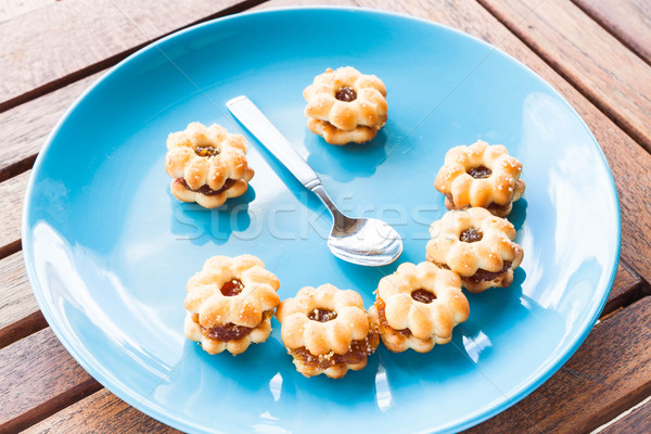 Smiling face of pineapple cookies on light blue dish Stock photo © nalinratphi