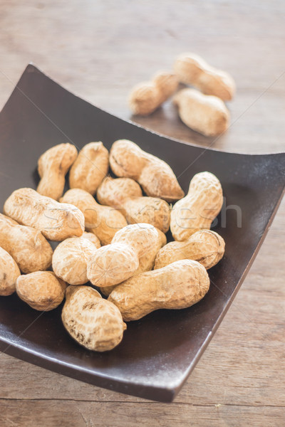 Salted peanuts on wooden bowl Stock photo © nalinratphi