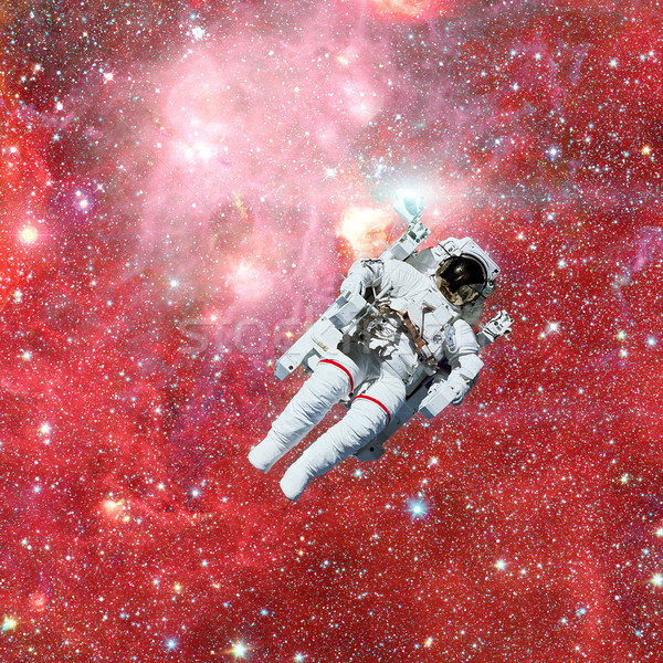 Stock photo: Astronaut in outer space. Nebula and stars on the background.