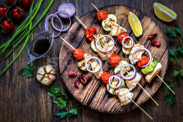 grilled chicken with zucchini, tomatoes, onions and herbs on wooden background Stock photo © Natalya_Maiorova