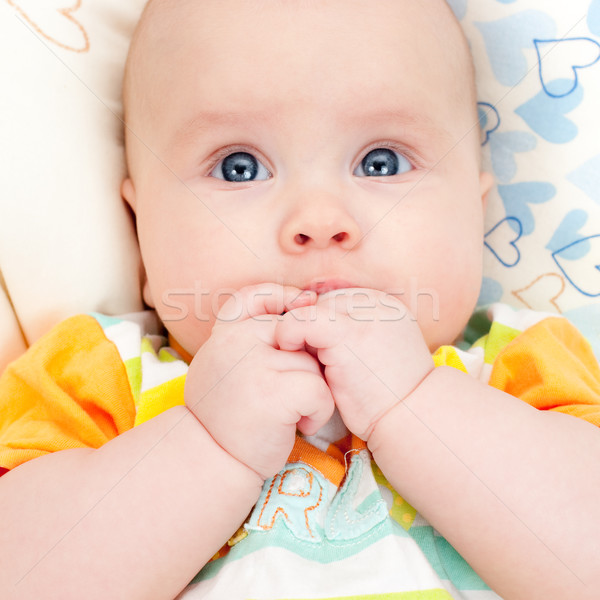 Infant with hands in mouth Stock photo © naumoid