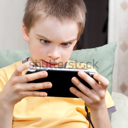 Boy playing game console Stock photo © naumoid