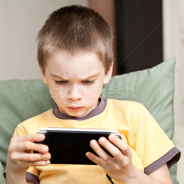 Boy playing game console Stock photo © naumoid