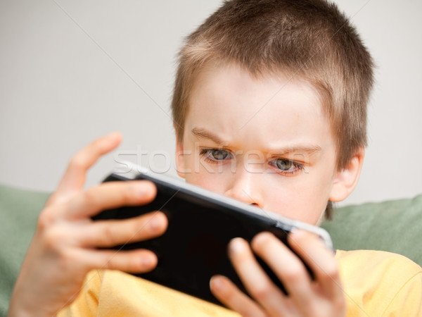 Boy playing game console Stock photo © naumoid