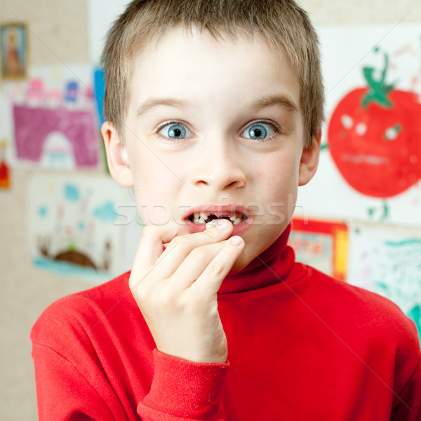 Boy holding missing teeth Stock photo © naumoid