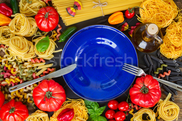 Raw pasta with ingridients and blue plate Stock photo © neirfy