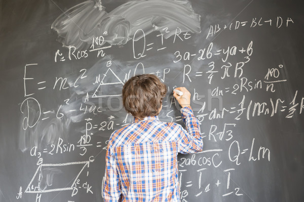 Boy writting on black board Stock photo © neirfy