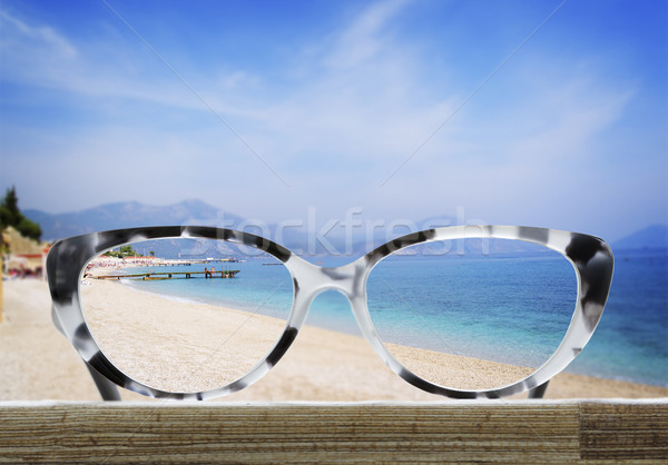 Stock photo: glasses on a wooden table in front of the sea