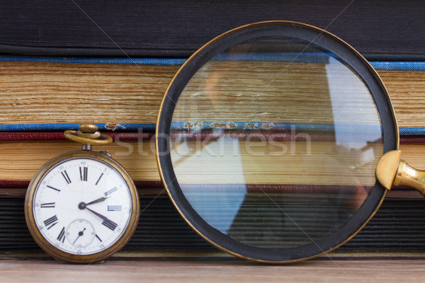 Stock photo: antique clock with loupe  on books background