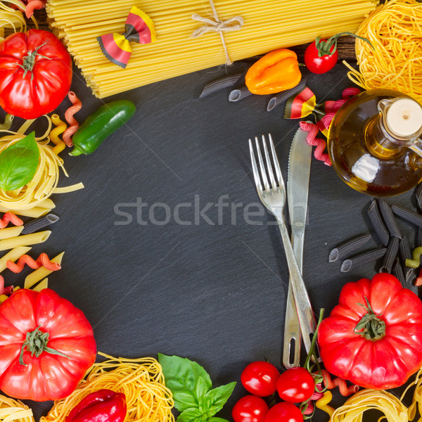 Raw pasta with ingridients on black board Stock photo © neirfy