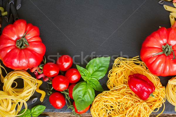 Raw pasta with ingridients on black board Stock photo © neirfy