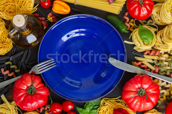 Raw pasta with ingridients and blue plate Stock photo © neirfy