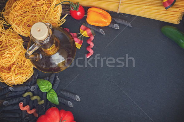 Raw pasta with ingridients on black board Stock photo © neirfy