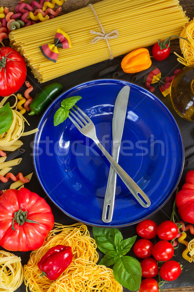 Raw pasta with ingridients and blue plate Stock photo © neirfy