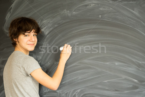 Boy writting on black board Stock photo © neirfy