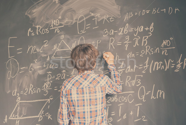 Boy writting on black board Stock photo © neirfy