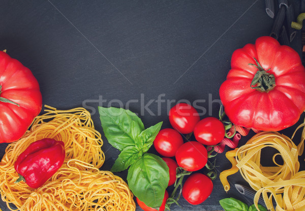 Raw pasta with ingridients on black board Stock photo © neirfy