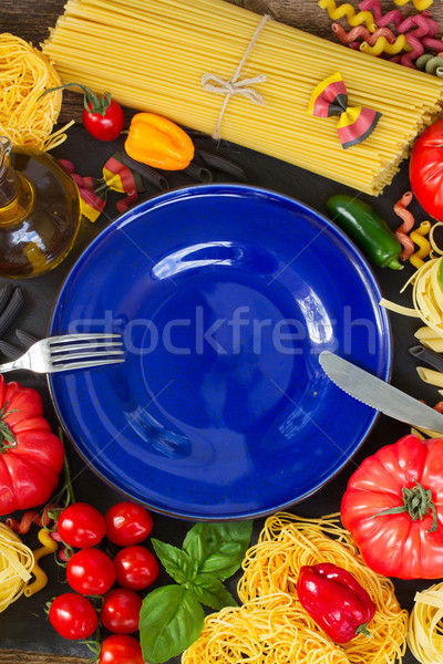 Raw pasta with ingridients and blue plate Stock photo © neirfy