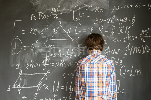 Boy writting on black board Stock photo © neirfy