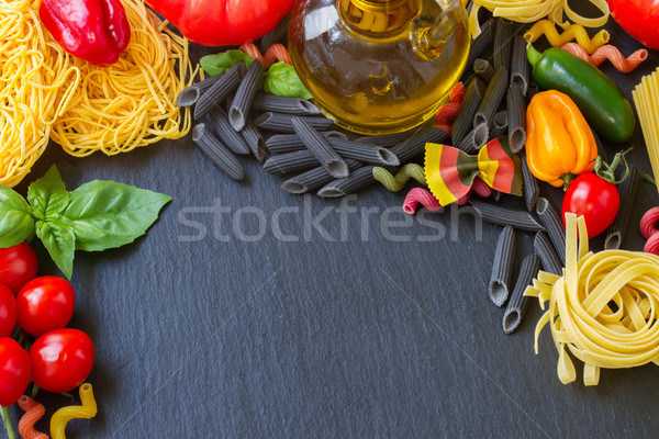 Raw pasta with ingridients on black board Stock photo © neirfy