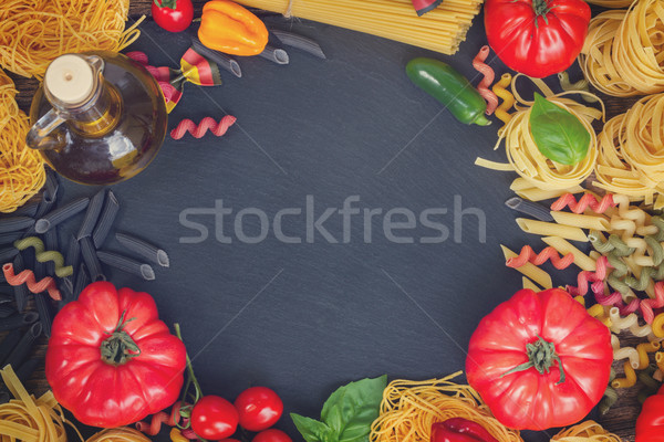 Raw pasta with ingridients on black board Stock photo © neirfy