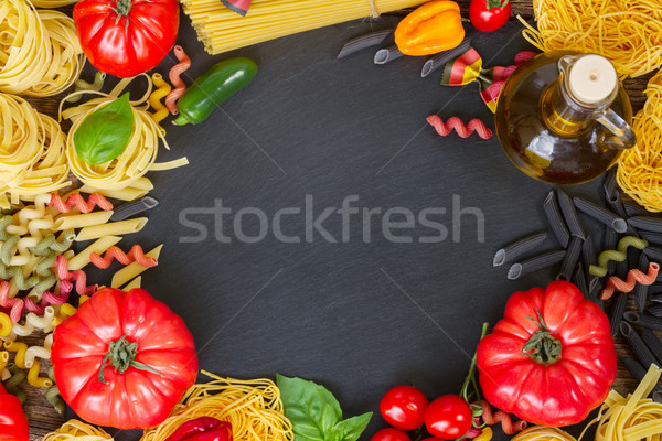 Raw pasta with ingridients on black board Stock photo © neirfy