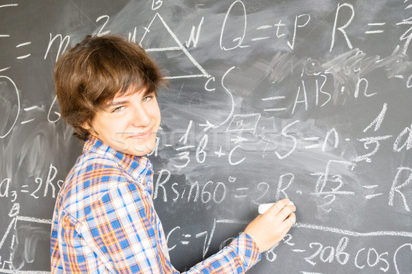 Boy writting on black board Stock photo © neirfy