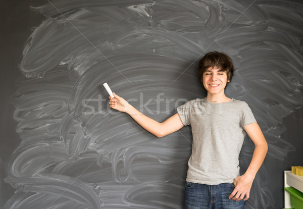 Boy writting on black board Stock photo © neirfy