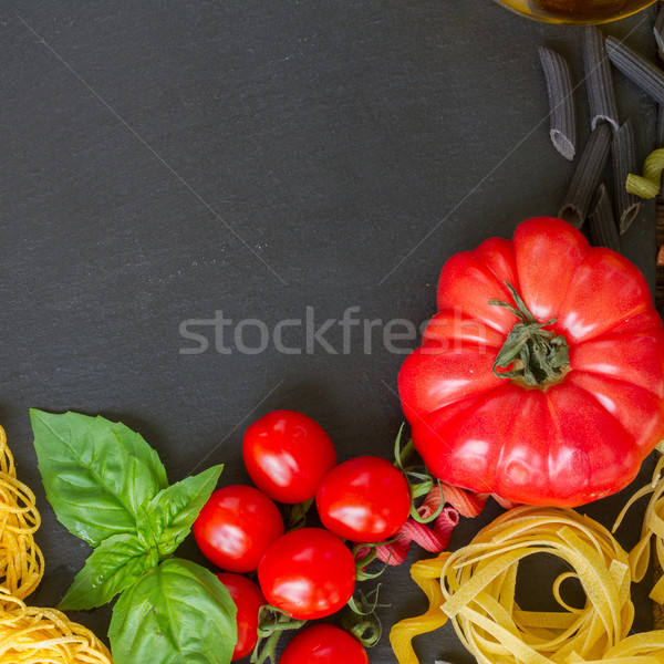 Raw pasta with ingridients on black board Stock photo © neirfy