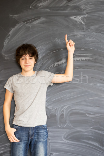 Boy writting on black board Stock photo © neirfy