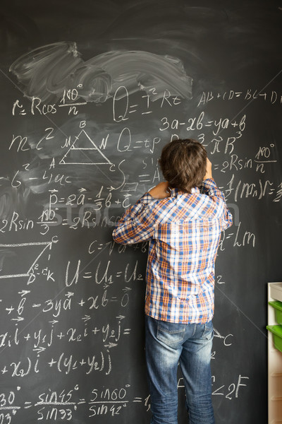 Boy writting on black board Stock photo © neirfy