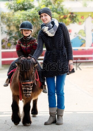 Foto stock: Pequeno · menino · capacete · equitação · pónei · sorrir