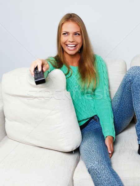 Young beautiful woman on a sofa with remote control  Stock photo © Nejron