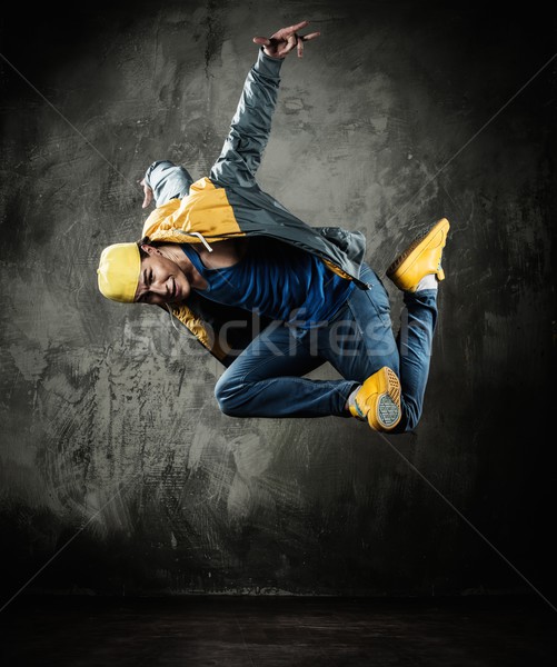 Man dancer in cap and jacket showing break-dancing moves Stock photo © Nejron