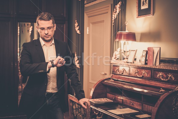 Middle-aged man looking at his wrist watch in luxury vintage style interior  Stock photo © Nejron