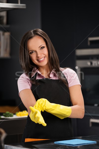 Beautiful cheerful brunette woman in gloves cleaning modern kitchen Stock photo © Nejron