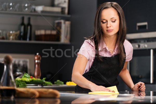 Stock photo: Young cheerful woman cleaning modern kitchen