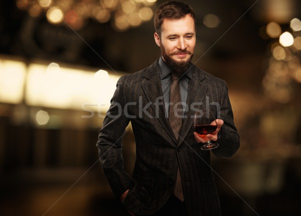 Handsome well-dressed man in jacket with glass of beverage  Stock photo © Nejron