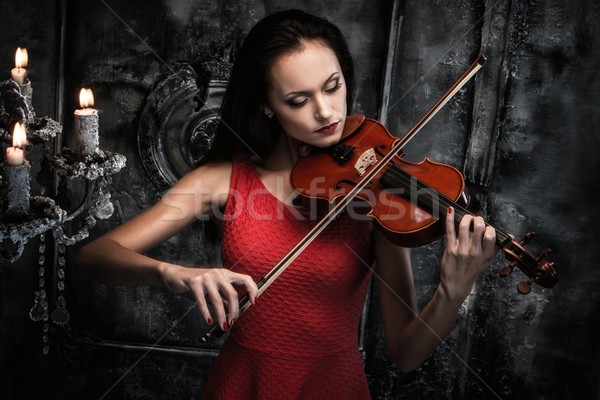 Młoda kobieta czerwona sukienka gry skrzypce mistyk wnętrza Zdjęcia stock © Nejron