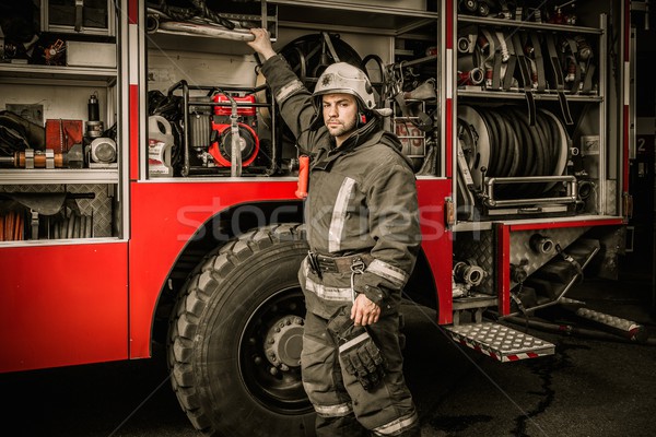 Fireman taking equipment from firefighting truck  Stock photo © Nejron