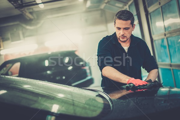 Cheerful worker wiping car on a car wash Stock photo © Nejron