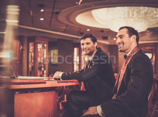 Two fashionable men in suits behind table in a casino Stock photo © Nejron