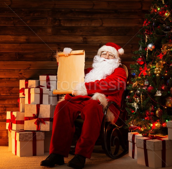 Santa Claus in wooden home interior holding blank wish list scroll Stock photo © Nejron