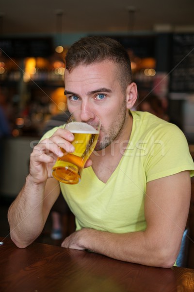 Jóképű fiatalember iszik világos sör kocsma üveg Stock fotó © Nejron