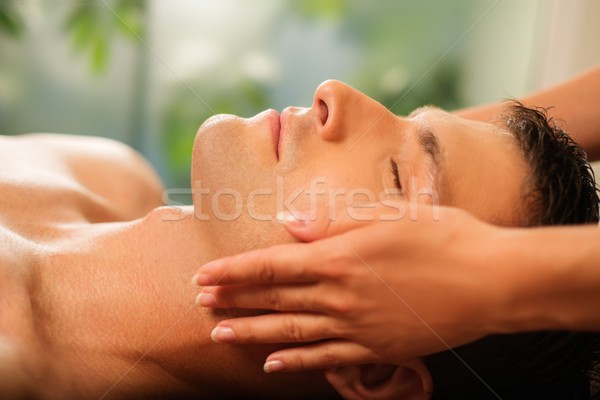 Handsome man having face massage in spa salon Stock photo © Nejron