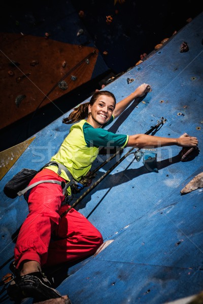 Young woman practicing rock-climbing on a rock wall indoors Stock photo © Nejron