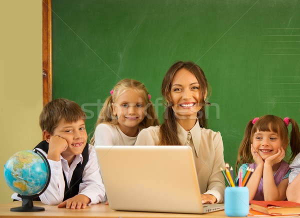 Group of happy classmates with their teacher in class near blackboard  Stock photo © Nejron