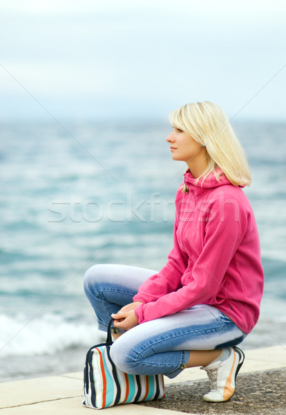 Sad woman sitting near the ocean Stock photo © Nejron