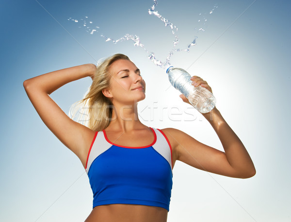 Young woman drinking water after fitness exercise Stock photo © Nejron
