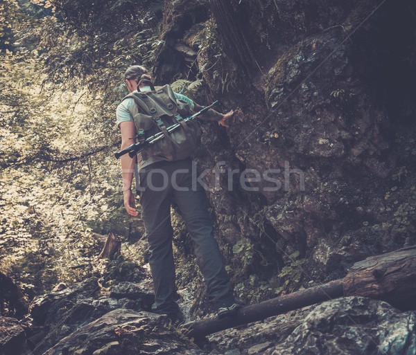 Man hiker walking across stream in mountain forest Stock photo © Nejron